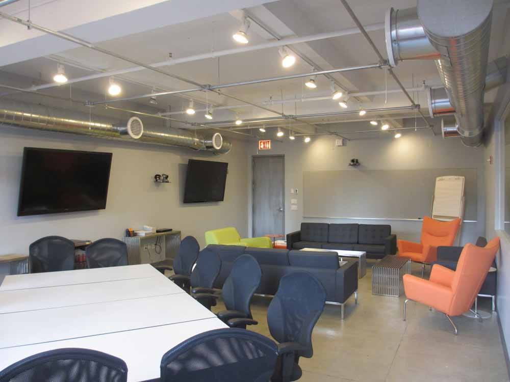 Resp-3-Loft Loft Style focus group room with conference table, living room area and TVs.