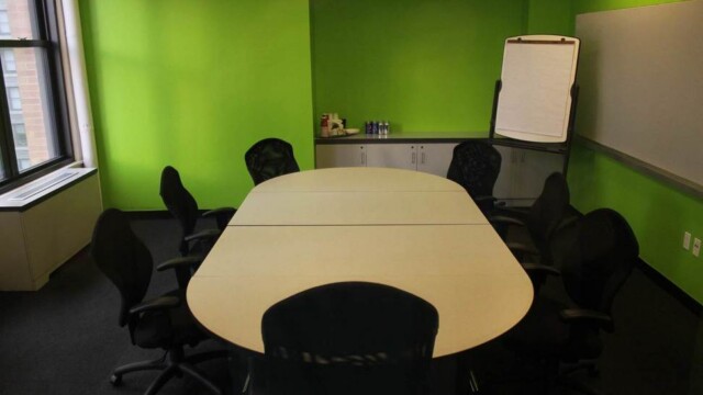 Focus group room configured with conference table, showing easel, green walls and push pin wall.