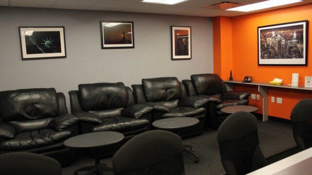 Focus group facility viewing room configured with oversized reclining black leather arm chairs.